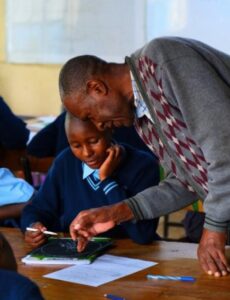 Patrick, the new art teacher, helps a student
