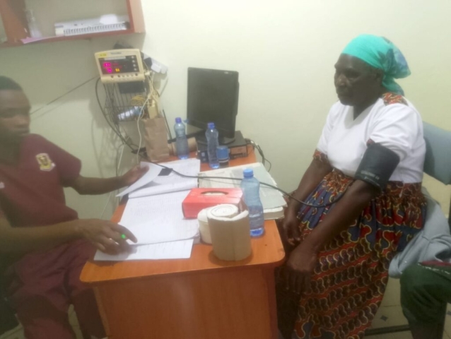 A medical student checks a woman's blood pressure.